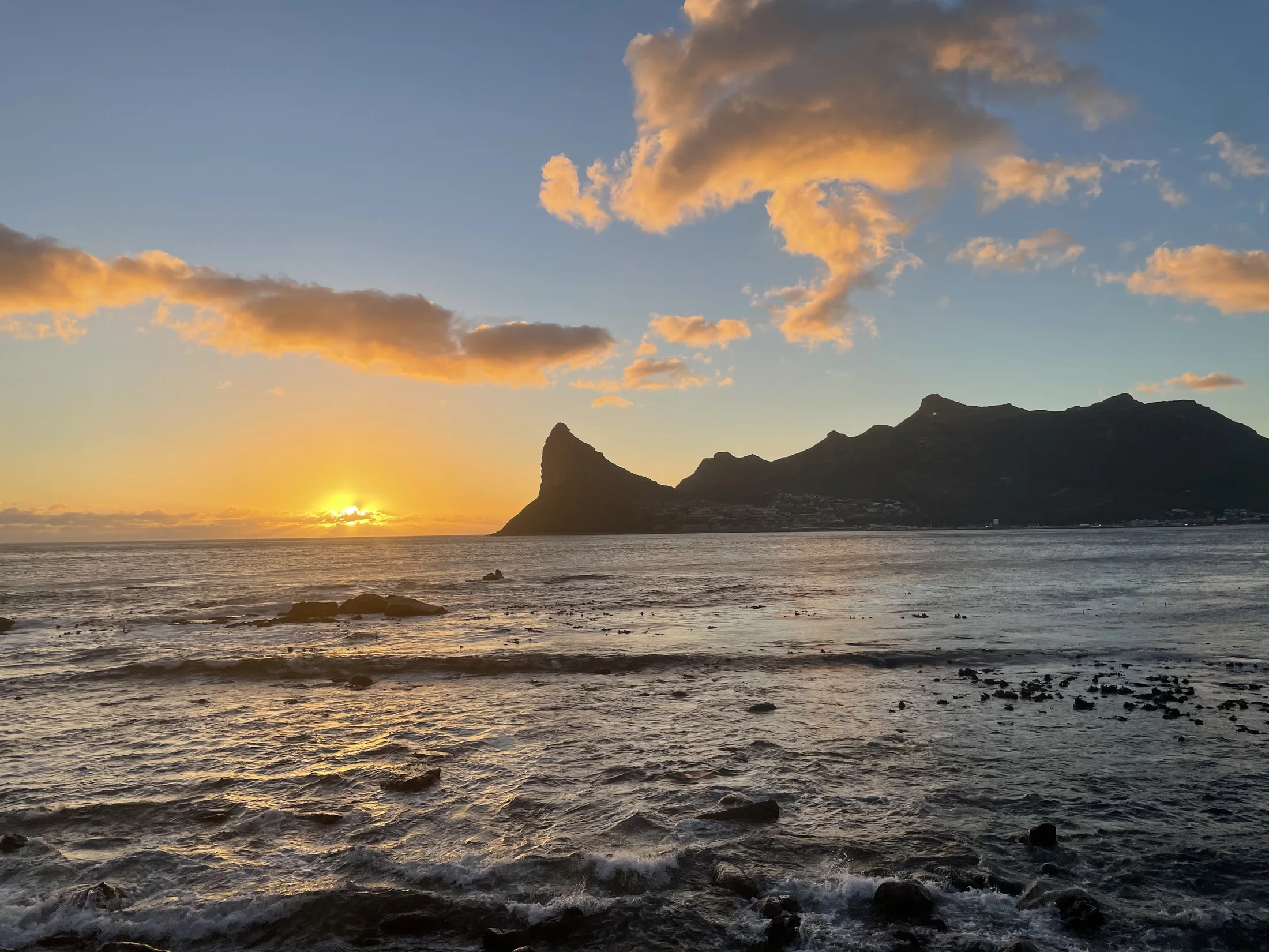 Hout Bay at sunset, seen across the water and mountains