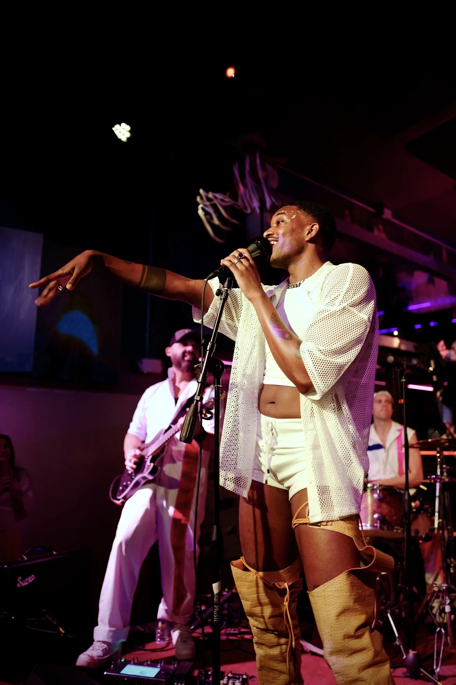 A live performer in white reaching toward the crowd