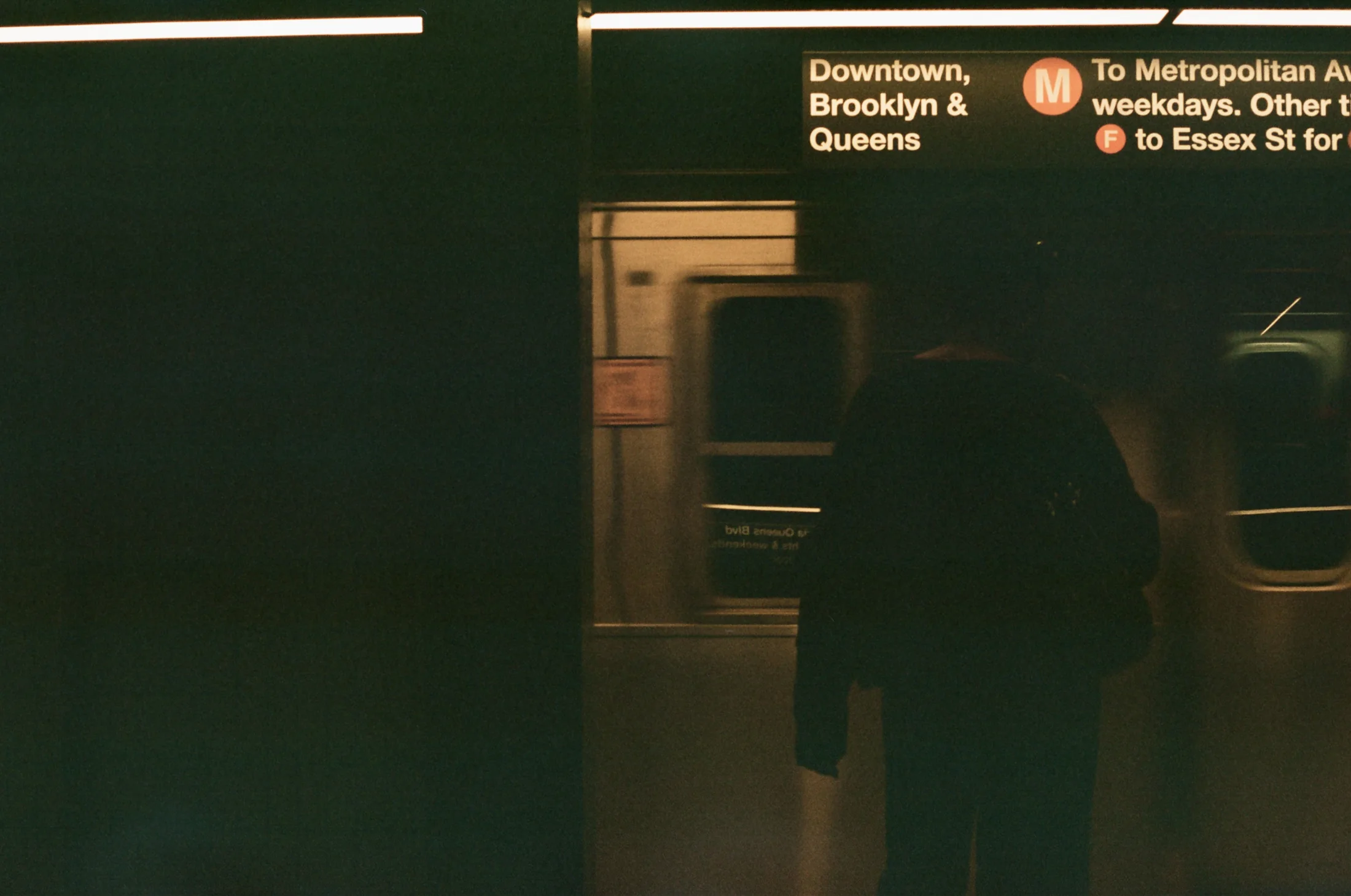 A passenger silhouetted inside a New York subway carriage